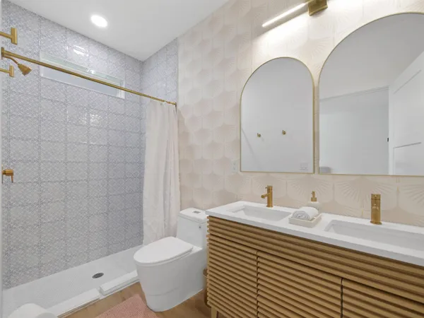 a bathroom with a sink toilet a mirror and shower
