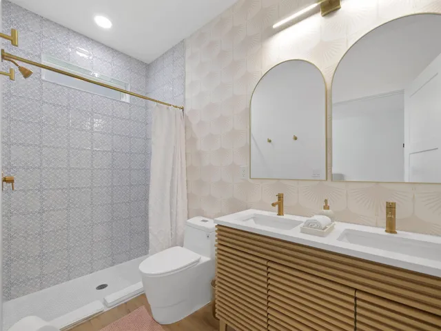 a bathroom with a sink toilet a mirror and shower