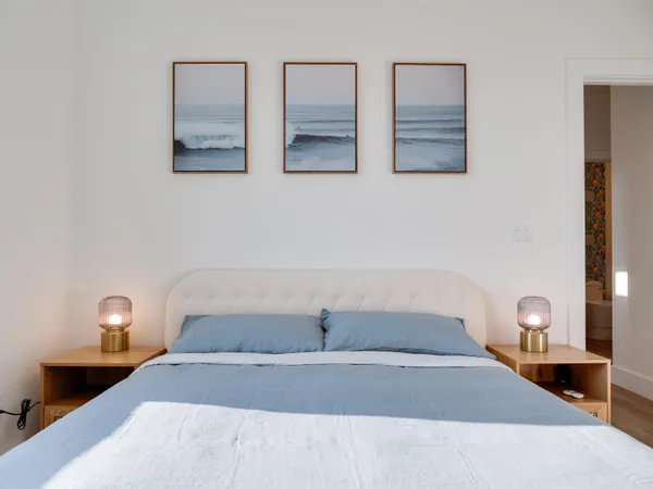 a bedroom with a bed and a painting on the wall