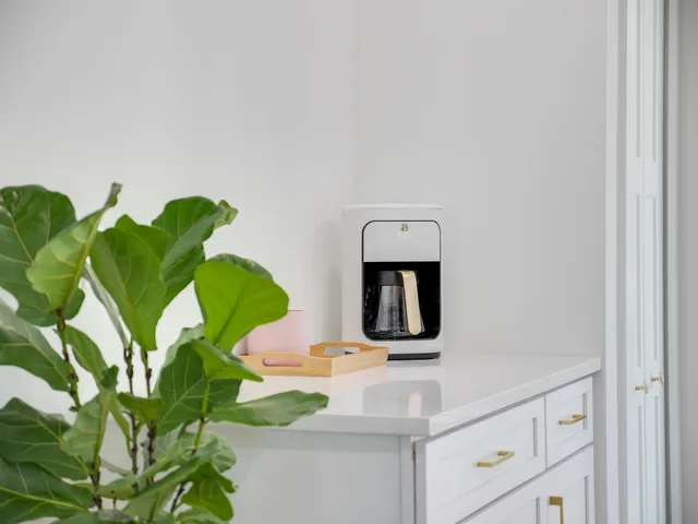 a kitchen with white cabinets and wooden floors