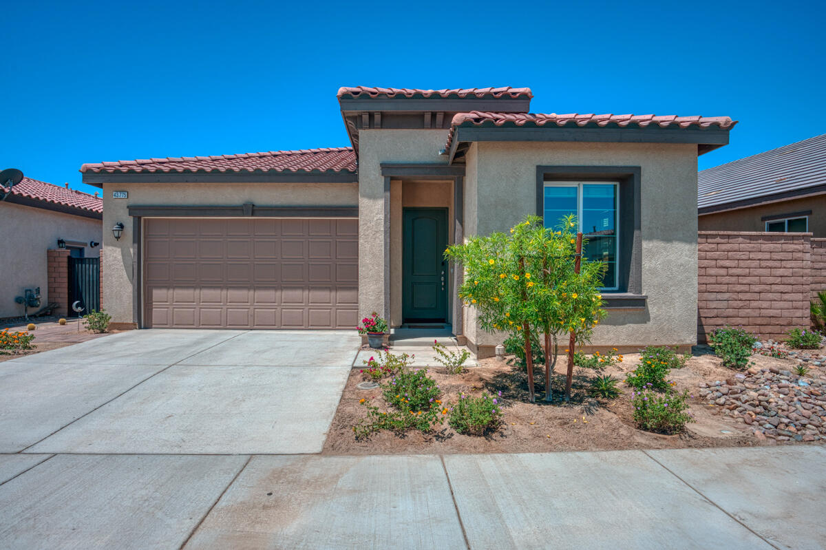 43775 Treviso Drive Indio, CA 92203 - Photo 1 of 47 a house with a flower garden and potted plants