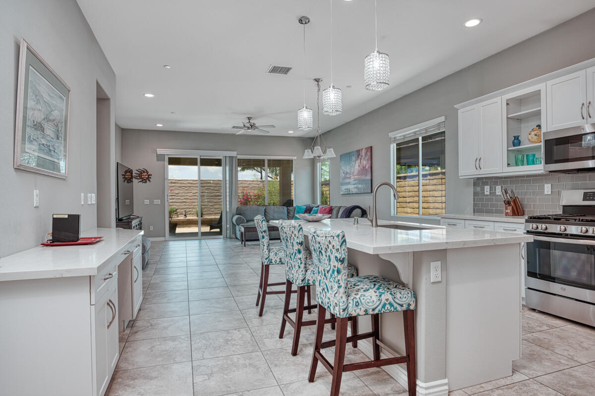 43775 Treviso Drive Indio, CA 92203 - Photo 2 of 47 a dining hall with stainless steel appliances granite countertop a stove a sink a oven a dining table and chairs