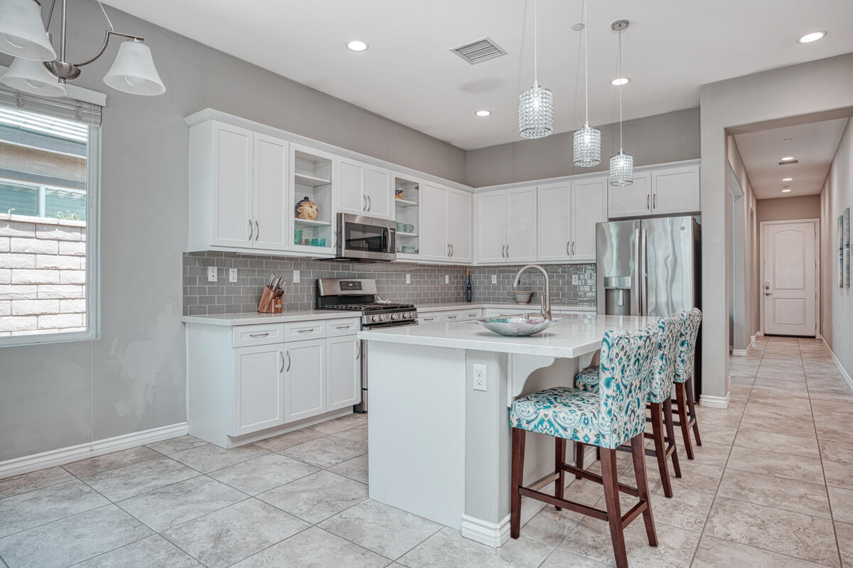43775 Treviso Drive Indio, CA 92203 - Photo 3 of 47 a kitchen that has a lot of white cabinets and stainless steel appliances
