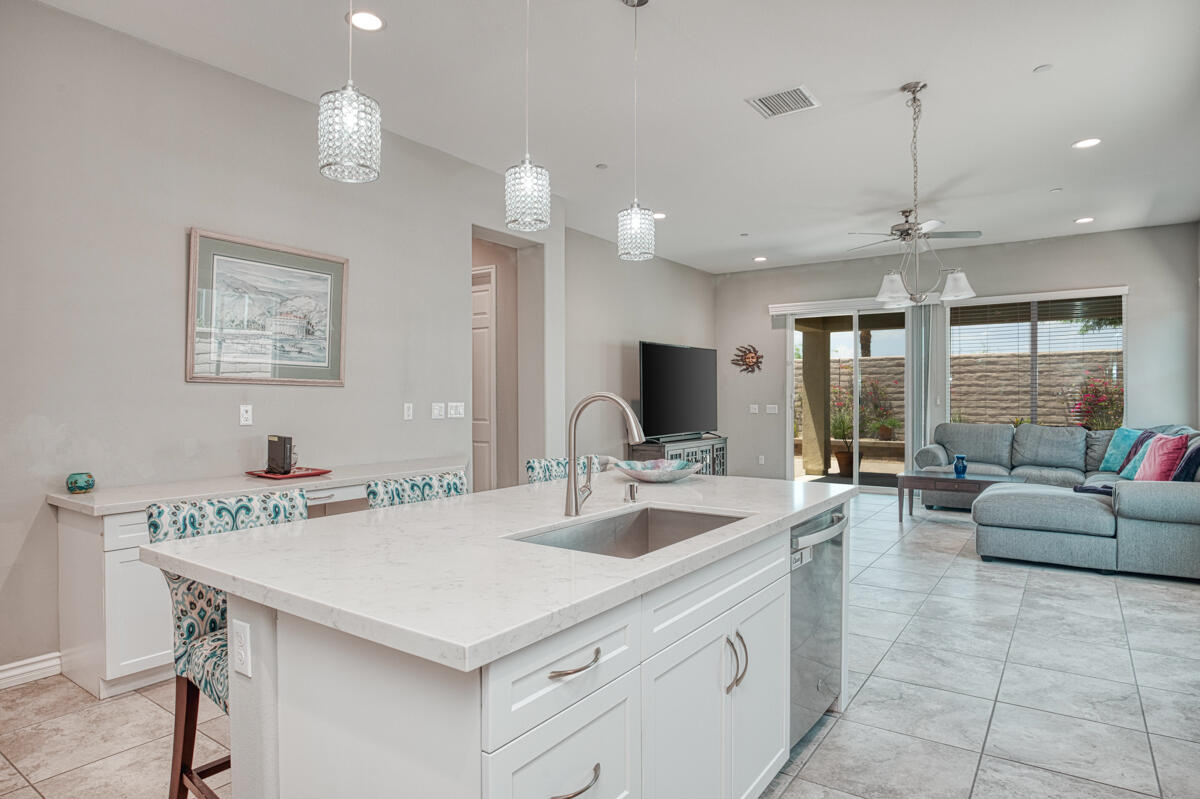 43775 Treviso Drive Indio, CA 92203 - Photo 6 of 47 a large white kitchen with a large island oven a sink stainless steel appliances and a large window