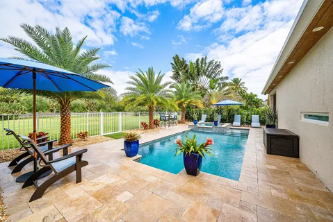 a palm tree sitting in front of a house with a garden