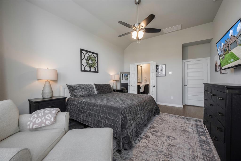 5664 Durst Lane Forney, TX 75126 - Photo 13 of 26 a spacious bedroom with a bed and a flat screen tv