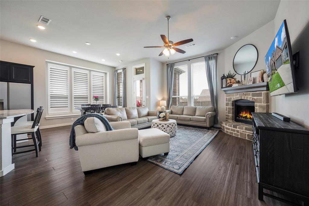 5664 Durst Lane Forney, TX 75126 - Photo 2 of 26 a living room with furniture a fireplace a flat screen tv and a large window
