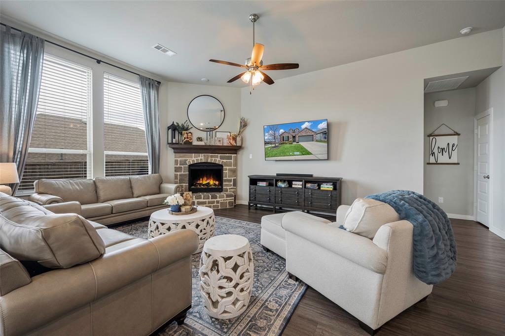 5664 Durst Lane Forney, TX 75126 - Photo 6 of 26 a living room with furniture a fireplace and a large window