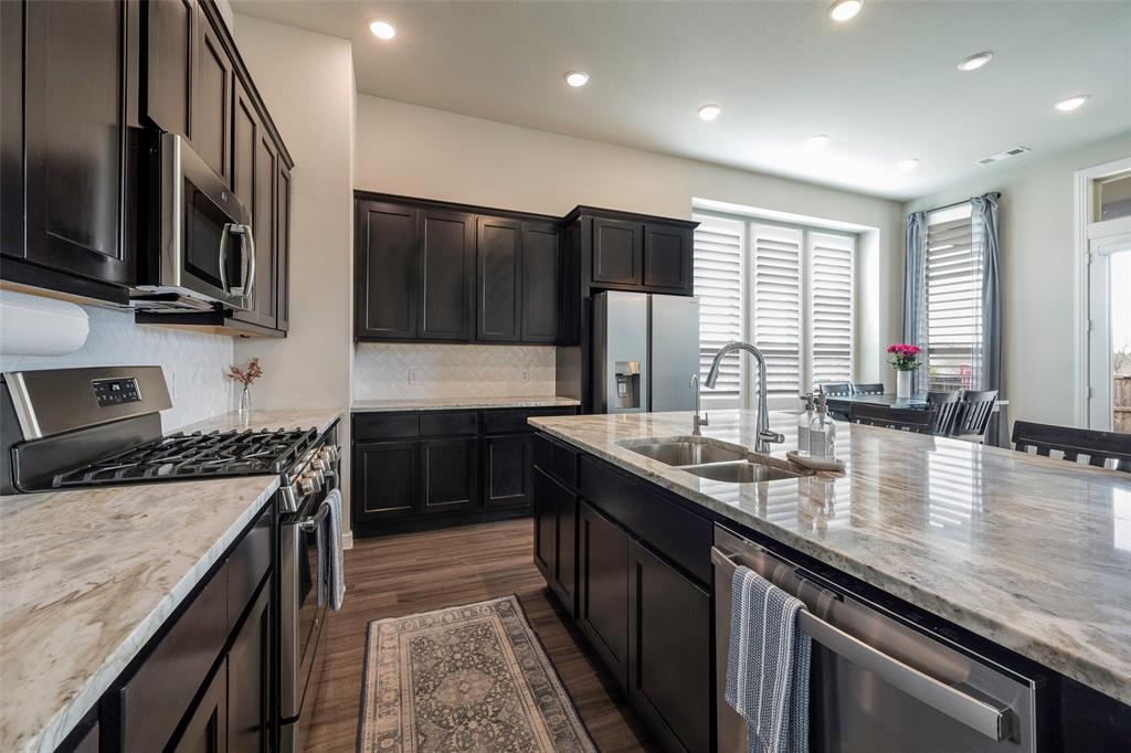 5664 Durst Lane Forney, TX 75126 - Photo 8 of 26 a kitchen with stainless steel appliances granite countertop a sink a stove and a refrigerator