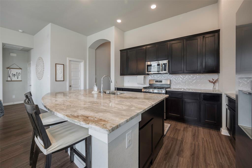 5664 Durst Lane Forney, TX 75126 - Photo 9 of 26 a kitchen with stainless steel appliances kitchen island granite countertop a stove a sink and a microwave