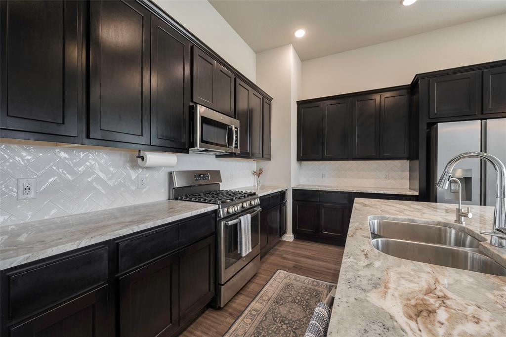 5664 Durst Lane Forney, TX 75126 - Photo 10 of 26 a kitchen with stainless steel appliances granite countertop a sink a stove a microwave and cabinets