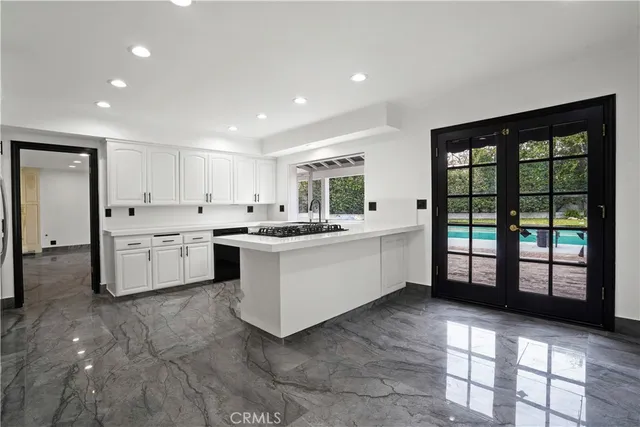 a large white kitchen with a large window