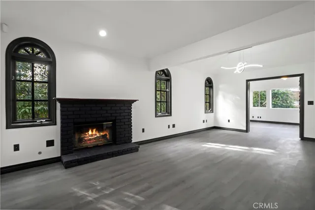a view of an empty room with a fireplace and window