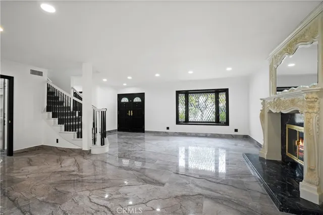 a view of an empty room with a fireplace and a window
