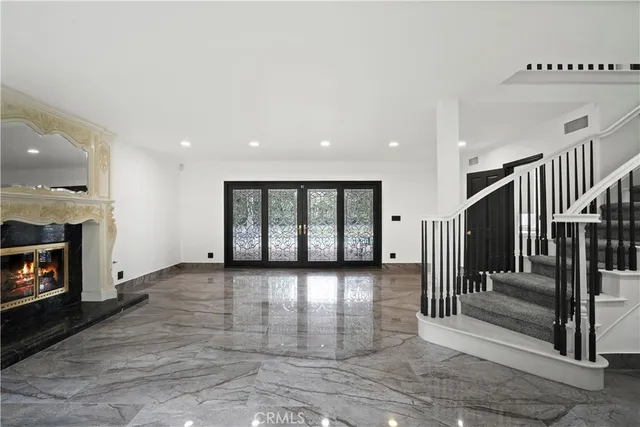 an empty room with wooden floor fireplace and windows