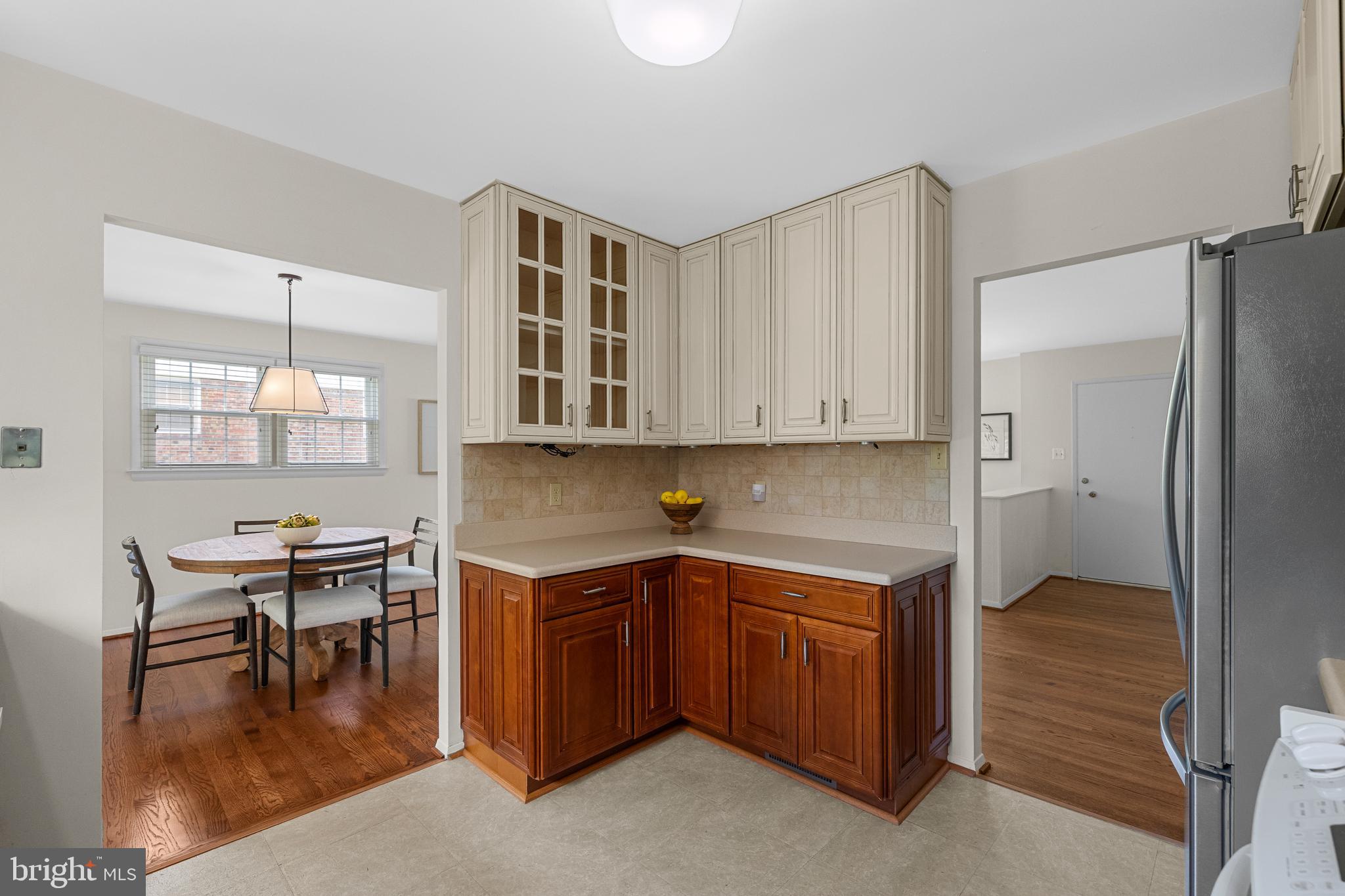 15007 Carlbern Drive Centreville, VA 20120 - Photo 23 of 47 a kitchen with stainless steel appliances granite countertop a table chairs in it and wooden floors