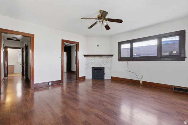 869 West Center Street Provo, UT 84601 - Photo 9 of 32 Unfurnished living room with dark wood-style floors, ceiling fan, and a fireplace