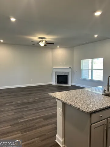 a kitchen with kitchen island a sink stainless steel appliances granite counter tops and a fireplace