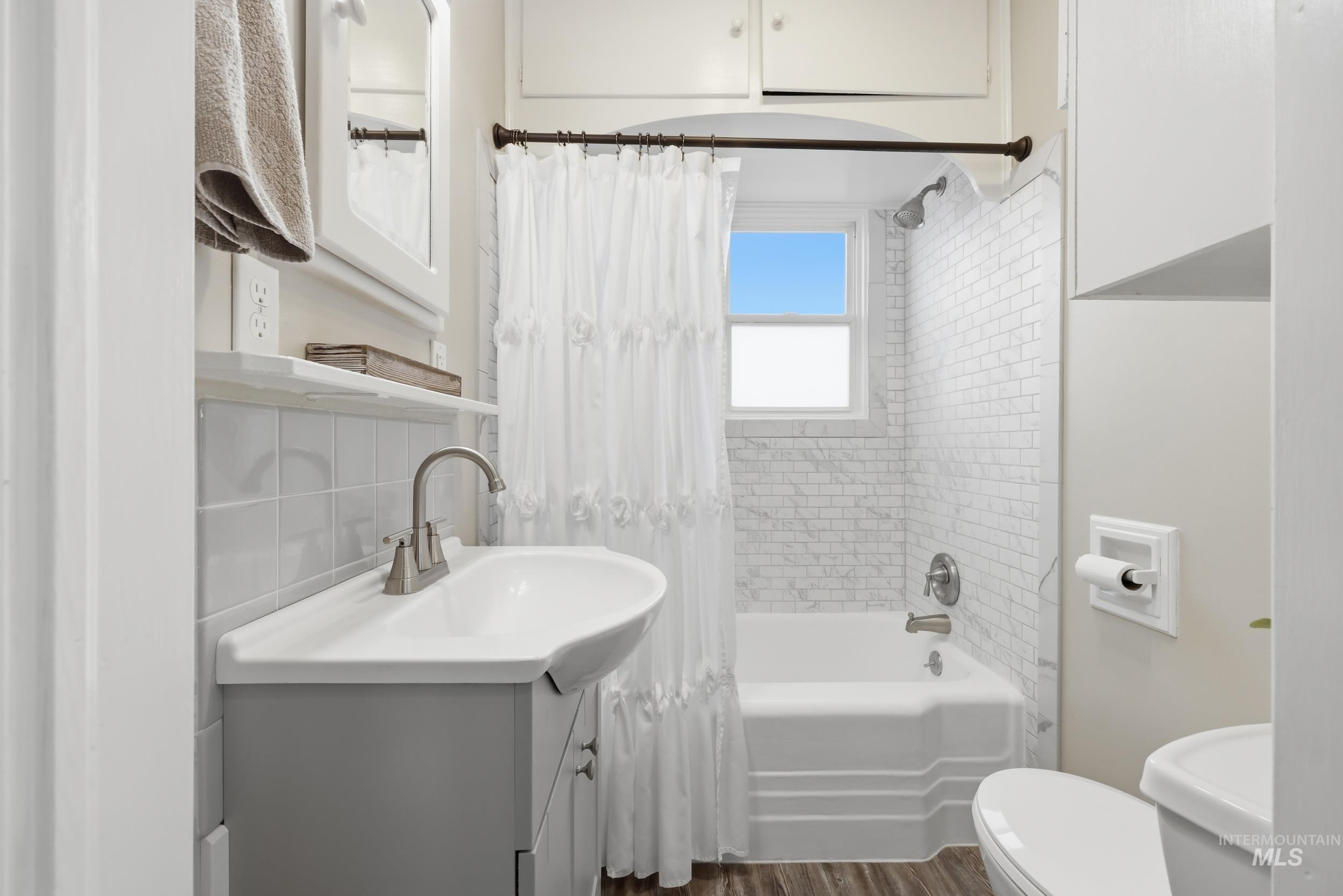 9762 Deer Flat Road Nampa, ID 83686 - Photo 5 of 24 Bathroom with vanity, shower / tub combo with curtain, and dark wood finished floors