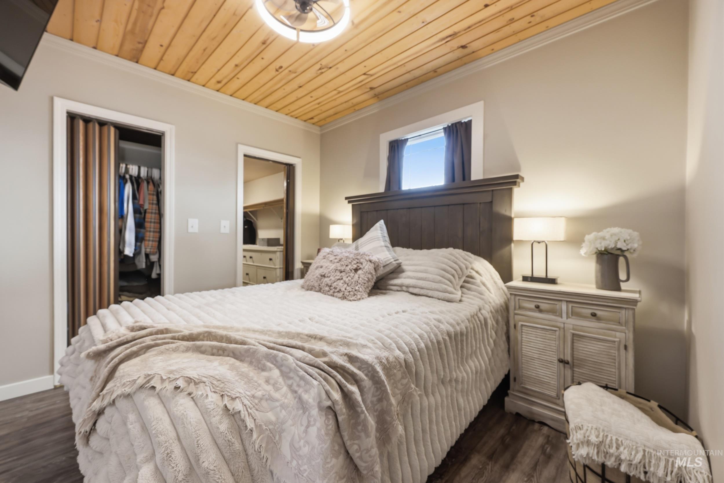 9762 Deer Flat Road Nampa, ID 83686 - Photo 6 of 24 Bedroom featuring a spacious closet, ornamental molding, dark wood-style flooring, and wood ceiling