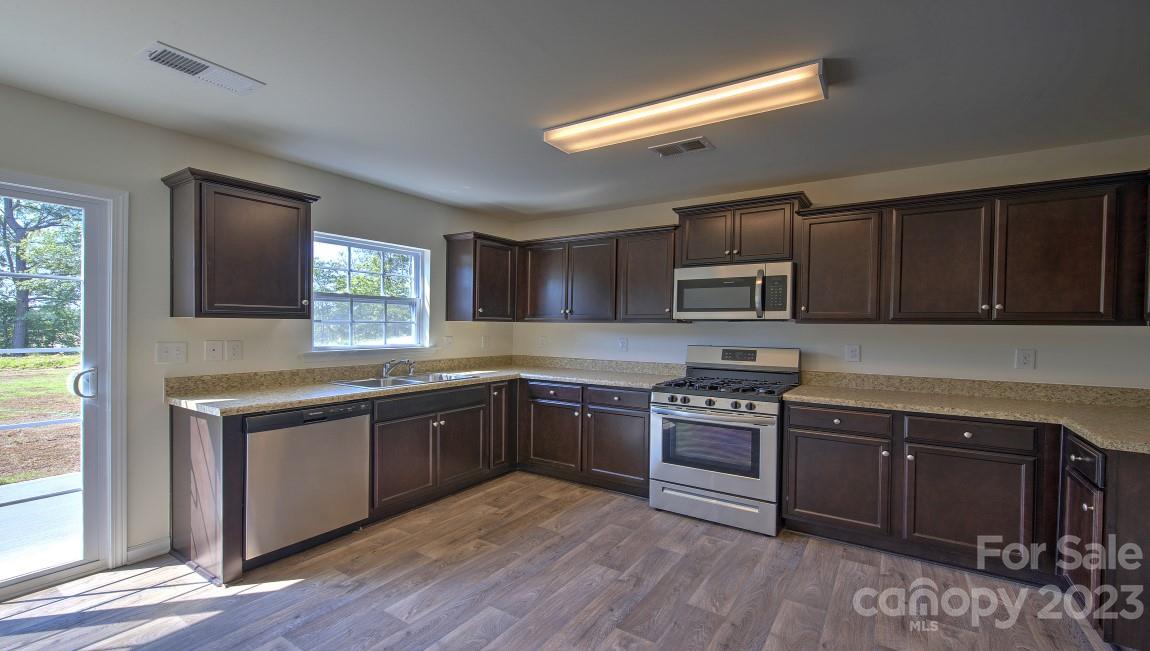 1374 Mifflin Lane Dallas, NC 28034 - Photo 6 of 20 a kitchen with stainless steel appliances granite countertop a stove a sink and a microwave