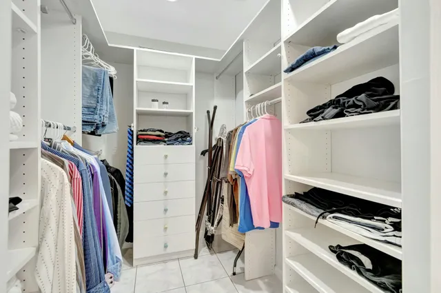 a view of walk in closet with clothes and shoes