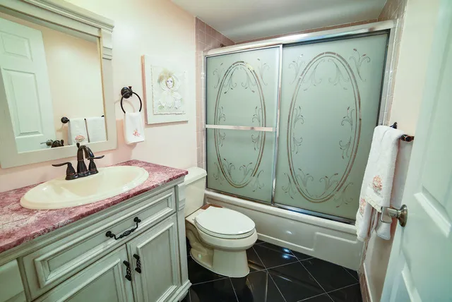 a bathroom with a sink a toilet and shower