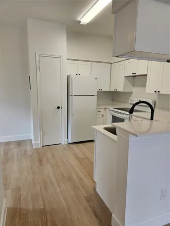a kitchen with stainless steel appliances a sink refrigerator and cabinets