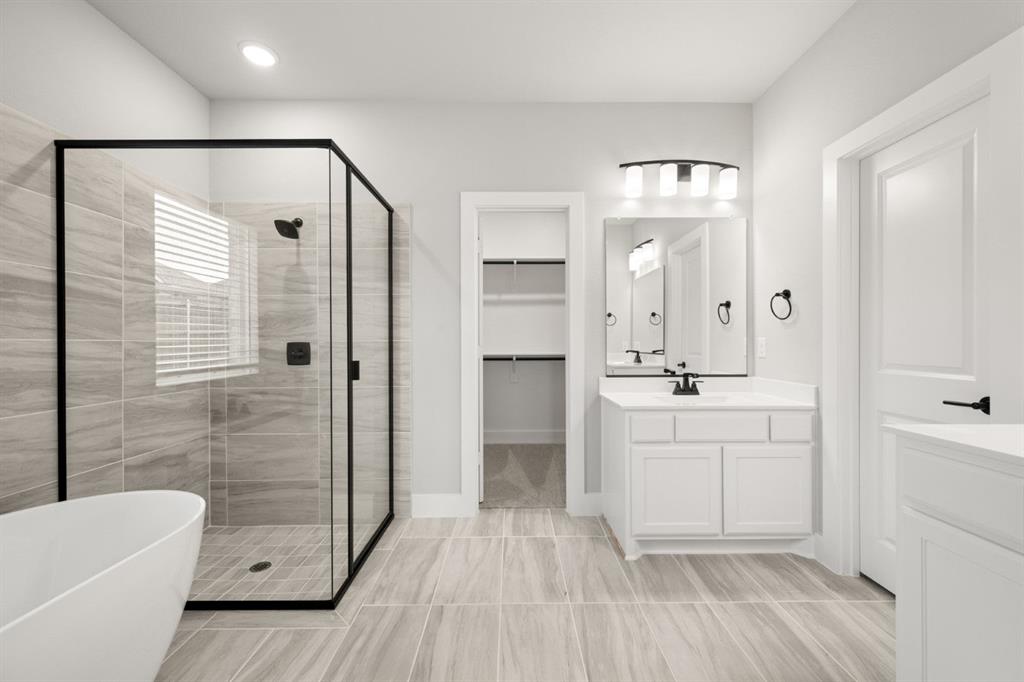 620 Red Maple Road Waxahachie, TX 75165 - Photo 14 of 40 a spacious bathroom with a shower a sink and a mirror
