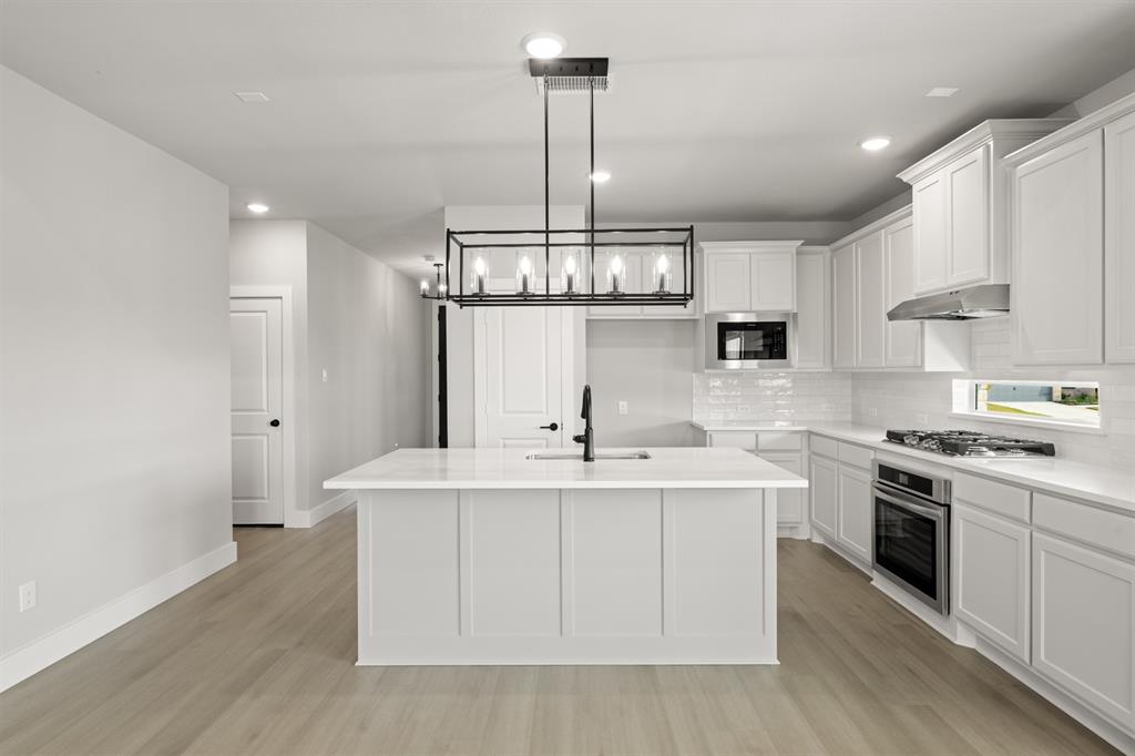 620 Red Maple Road Waxahachie, TX 75165 - Photo 21 of 40 a kitchen with stainless steel appliances a sink stove and cabinets