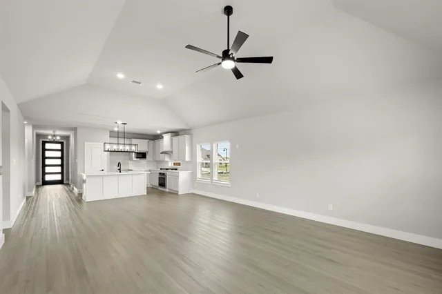 an empty room with fan and windows