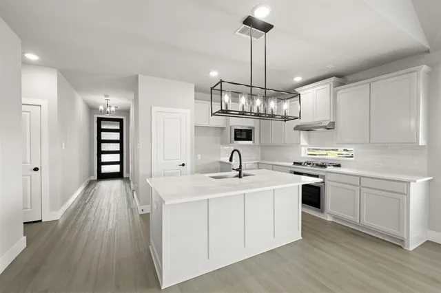 a kitchen with stainless steel appliances granite countertop a sink stove and refrigerator