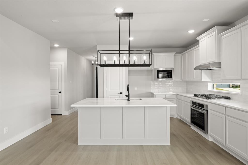 620 Red Maple Road Waxahachie, TX 75165 - Photo 4 of 40 a kitchen with stainless steel appliances a sink stove and cabinets