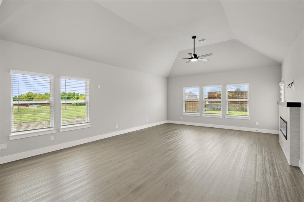 620 Red Maple Road Waxahachie, TX 75165 - Photo 9 of 40 a view of an empty room with wooden floor and a window