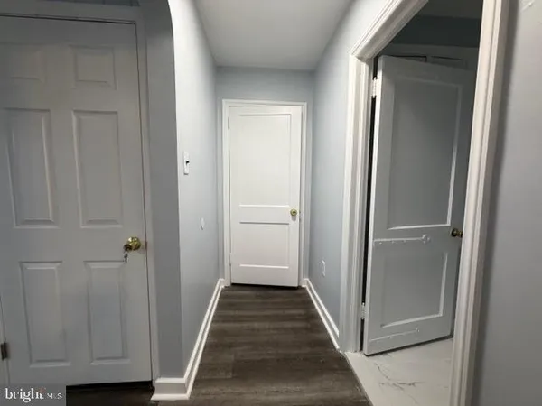 a view of a hallway with wooden floor and closet area