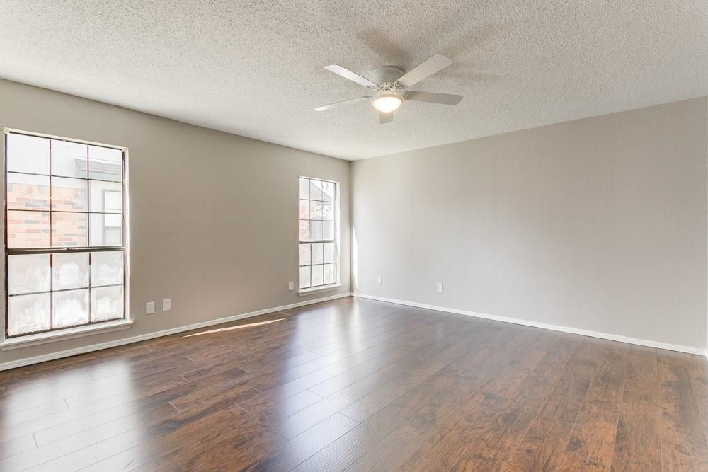 9421 Shipman Street Rowlett, TX 75088 - Photo 21 of 29 an empty room with wooden floor fan and windows