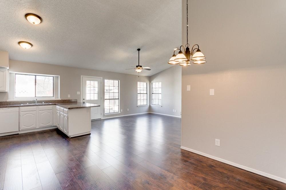 9421 Shipman Street Rowlett, TX 75088 - Photo 8 of 29 a view of an empty room and kitchen with wooden floor