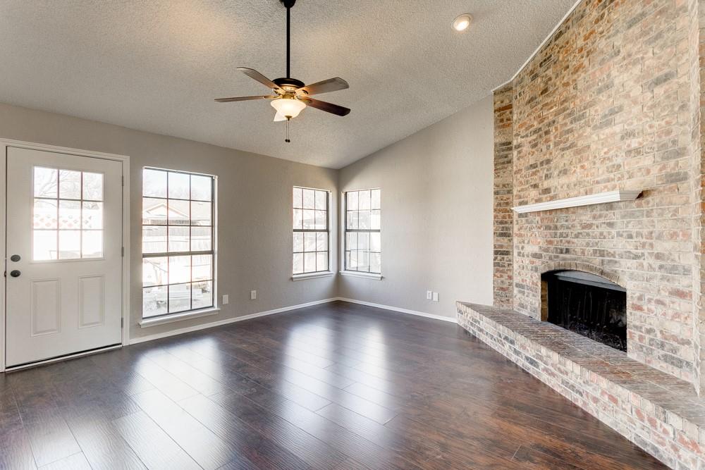 9421 Shipman Street Rowlett, TX 75088 - Photo 9 of 29 a view of an empty room with wooden floor fireplace and a window