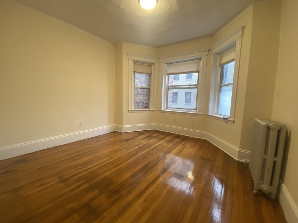 327 Huntington Avenue, Unit 31 Boston, MA 02115 - Photo 2 of 3 a view of an empty room with a window and wooden floor