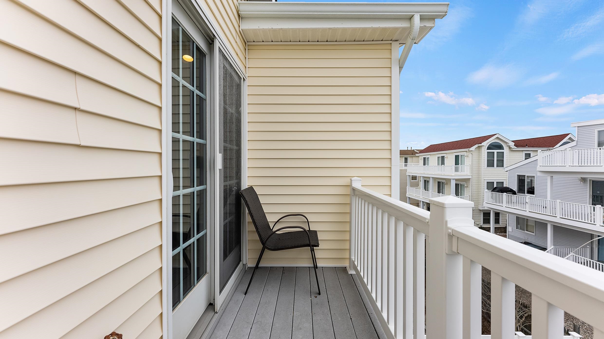 9 78th Street, Unit WEST Sea Isle City, NJ 08243 - Photo 14 of 24 a view of a balcony with furniture and wooden floor