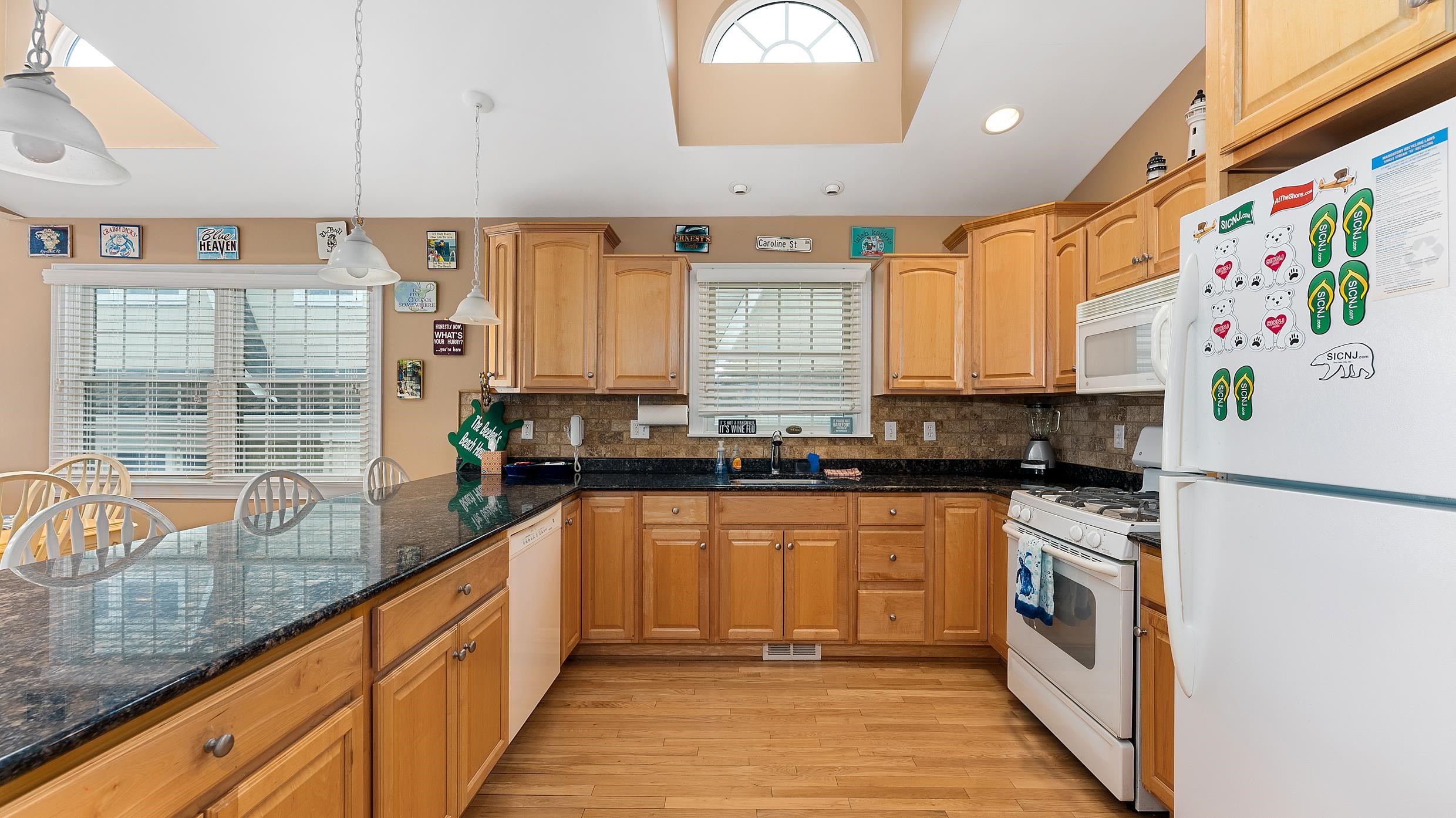 9 78th Street, Unit WEST Sea Isle City, NJ 08243 - Photo 8 of 24 a kitchen with stainless steel appliances granite countertop a sink a stove and a refrigerator