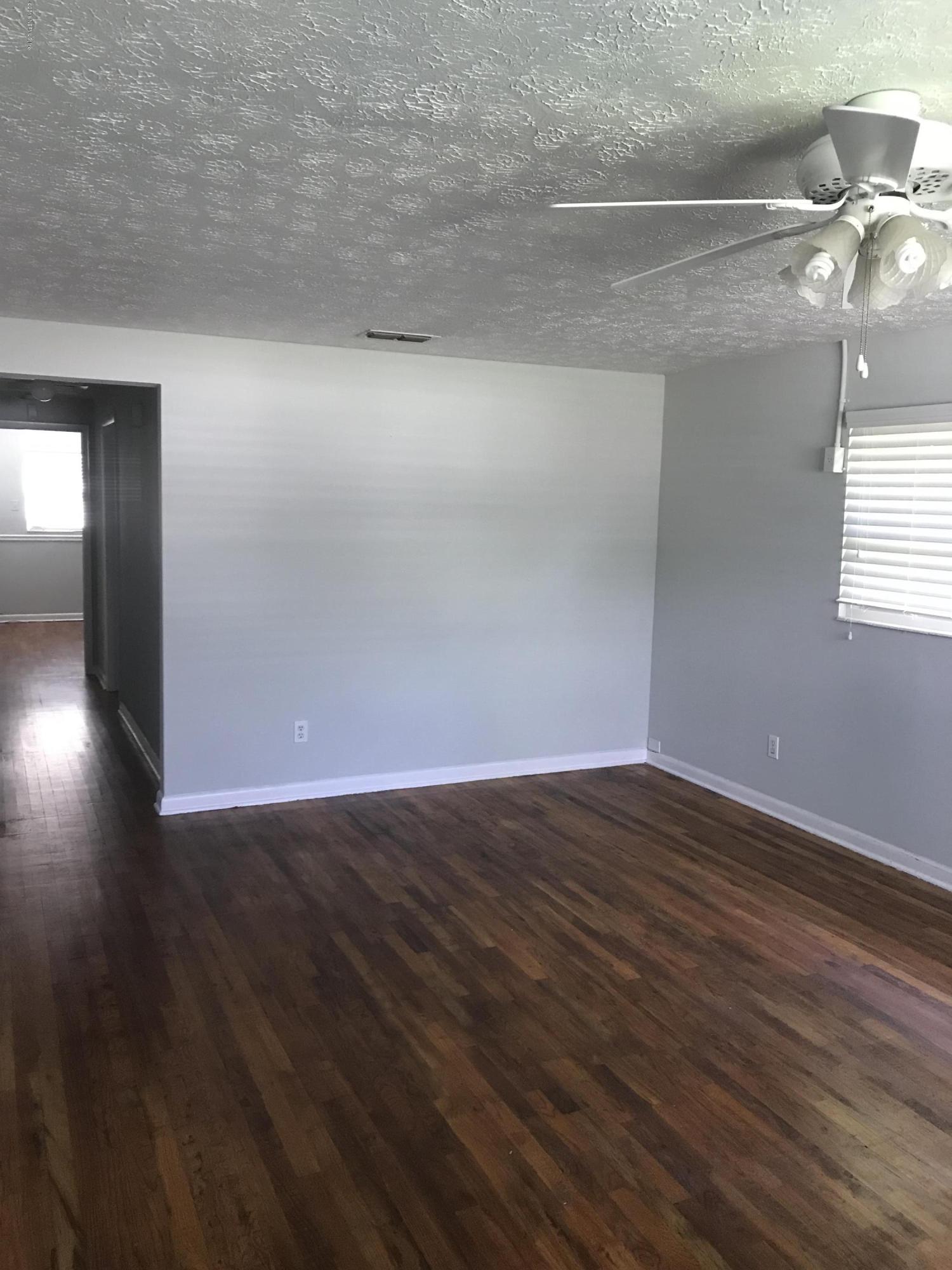 421 Skate Road Atlantic Beach, FL 32233 - Photo 5 of 18 a view of an empty room with wooden floor and a window