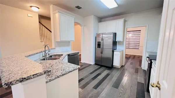 a kitchen with stainless steel appliances granite countertop a refrigerator and a sink