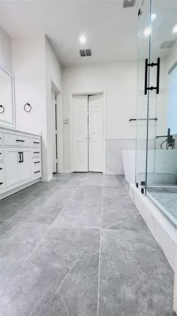 a bathroom with a tub a shower a mirror and a shower