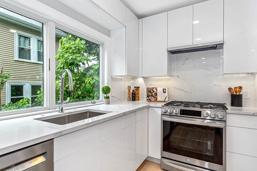 36-38 Johnswood Road Boston, MA 02131 - Photo 11 of 42 a kitchen with granite countertop a sink a stove and a microwave