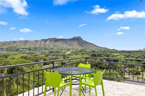 a view of a city from a balcony with chairs