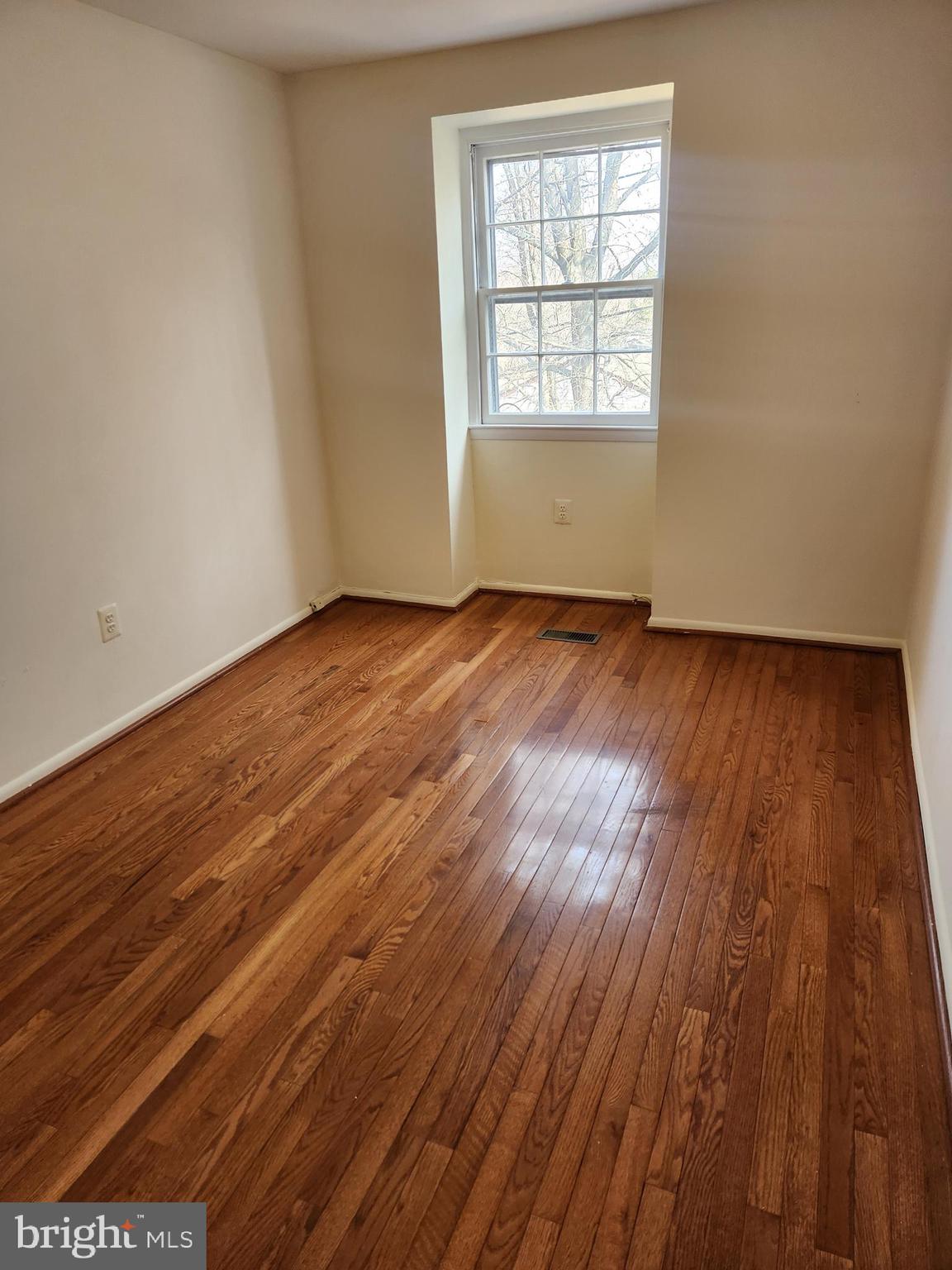 8509 Imperial Drive, Unit 7B Laurel, MD 20708 - Photo 19 of 36 an empty room with wooden floor and windows
