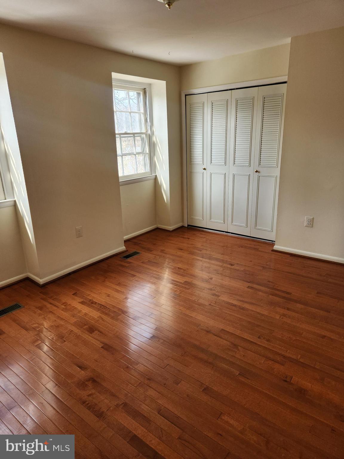 8509 Imperial Drive, Unit 7B Laurel, MD 20708 - Photo 20 of 36 an empty room with wooden floor and windows