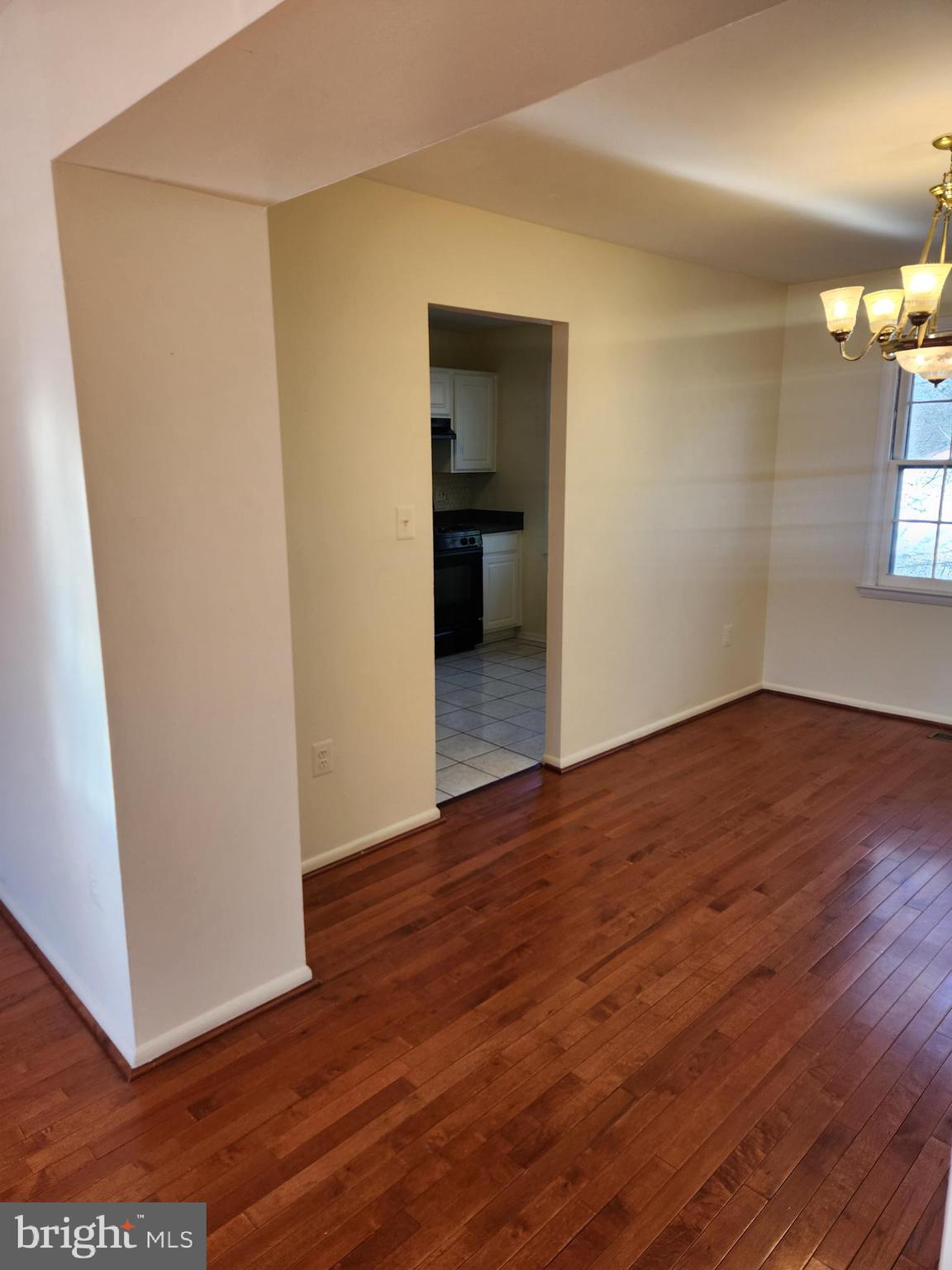 8509 Imperial Drive, Unit 7B Laurel, MD 20708 - Photo 8 of 36 a view of a hallway with wooden floor and a kitchen