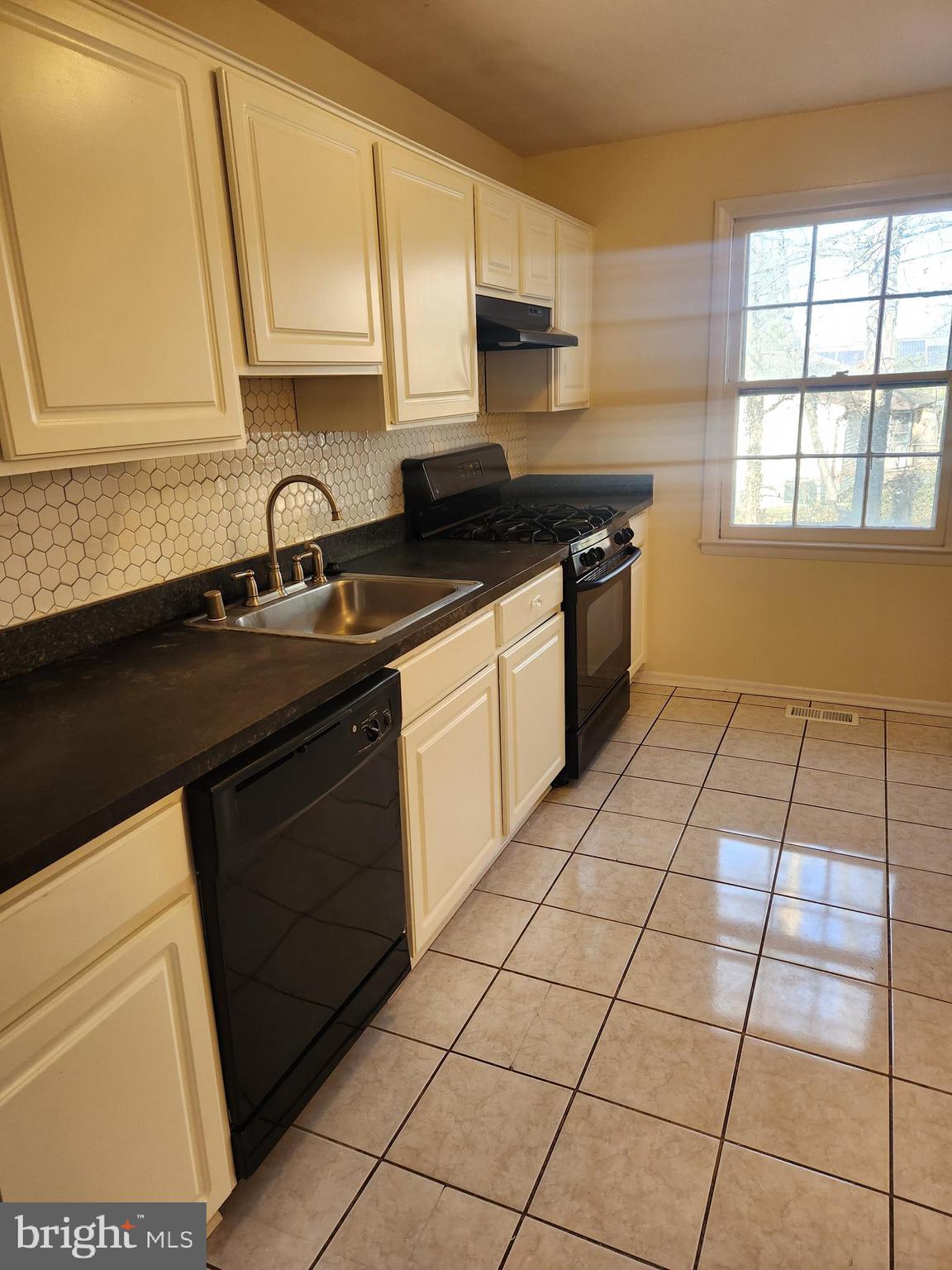 8509 Imperial Drive, Unit 7B Laurel, MD 20708 - Photo 10 of 36 a kitchen with a sink a stove cabinets and a window